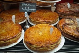 Display of galettes des rois arranged in a French pâtisserie.