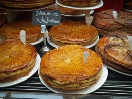 Display of galettes des rois arranged in a French p&acirc;tisserie.